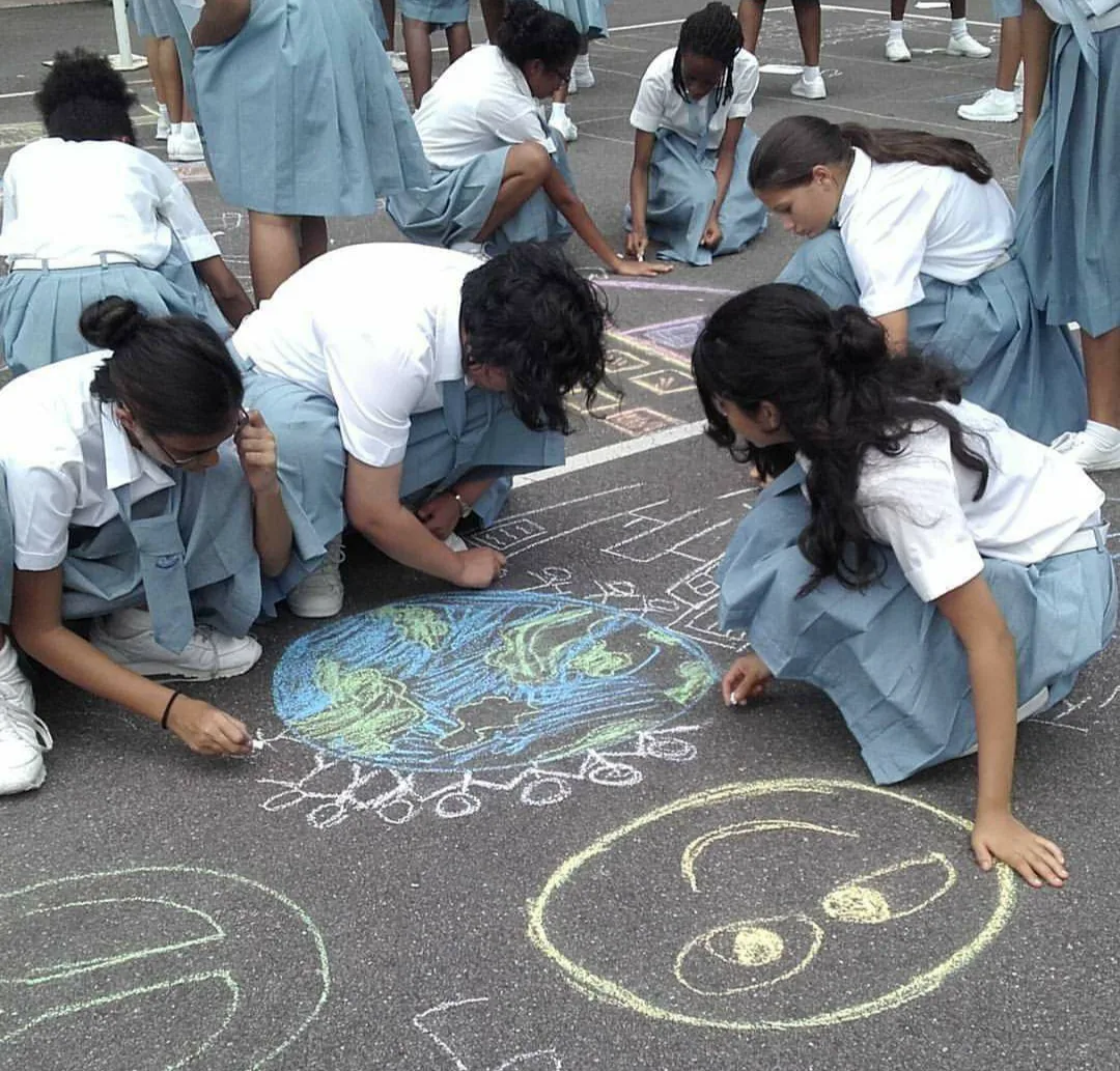 Students working together on colourful chalk artwork about the world and peace